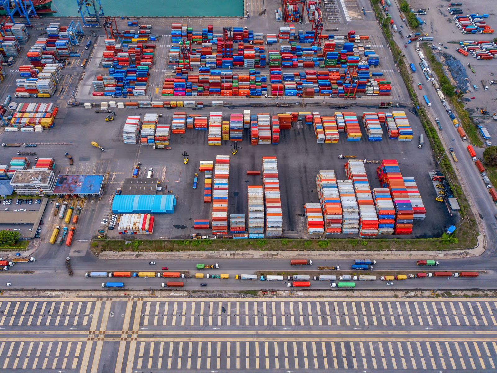 Loading cargo through the narrow end of a standard shipping container is one of the biggest frustrations in logistics. Forklifts struggle with long loads, workers waste time arranging items single-file, and oversized materials simply do not fit through a 7-foot-wide door. The open side container solves these problems by placing full-length doors along the long wall. In this guide, we cover what an open side container is, how the doors work, standard dimensions, real-world applications, pricing, and how it compares to other container types. Infinex can source open side containers for projects across Singapore in both new and used condition. What Is an Open Side Container? An open side container (also called a full-side access container, side-opening container, or side-door container) is a modified intermodal shipping container with bi-fold doors along one or both of its long walls instead of the conventional solid steel panels. While a standard container only has cargo doors on the short 8-foot wall, an open side container opens up the full 20-foot or 40-foot length of its side wall. This gives operators the ability to load, unload, and access cargo from the side rather than being restricted to end-loading only. The bi-fold doors are made from the same corrugated Corten steel as the rest of the container. When closed and sealed, the unit remains wind-tight and water-tight, just like a standard box. Structural integrity is maintained through a reinforced top rail, reinforced corner posts, and carefully engineered hinge systems. Open side containers are built to ISO standards and are compatible with standard container handling equipment. They are available in both 20ft and 40ft lengths, in standard height (8ft 6in) and high cube (9ft 6in) configurations. For a full breakdown of sizing, see our container sizes guide. https://app.envato.com/search/photos/0eb3cb14-fd6f-44ce-b3dc-915d3b4ac1ad?itemType=photos&term=Open+Side+Container&sort=relevance How Open Side Container Doors Work The door system is what sets the open side container apart. Understanding the mechanism, design variants, and opening options will help you choose the right configuration. Bi-Fold Door Mechanism Each door panel is made up of two hinged sections that fold against each other when opened, similar to a closet bi-fold door but built to industrial standards. The doors swing open between 180 and 270 degrees, and when fully opened, the panels fold flat against the adjacent wall or corner post, leaving the entire side opening completely clear. Each panel rides on heavy-duty hinges welded to vertical posts, designed to support 150 to 250 kg per panel while withstanding repeated opening and closing cycles. Doors can be opened individually or all at once, giving you flexibility for partial or full access. Door Configurations Full open-side (no centre post): Two large bi-fold assemblies meet in the middle. When opened, the entire wall is clear with no vertical obstruction. Best for very long or wide items. One-post/two-door: A single vertical centre post divides the side into two openings, each with its own bi-fold assembly. Adds structural rigidity while providing generous access. Four-door/three-post: Three vertical posts create four equal door sections. Highest structural strength, commonly chosen when stacking is required. Most open side containers also retain the standard end doors, giving you dual-access capability. Weatherproofing and Security Despite having an entire wall that opens, open side containers are engineered to be fully weather-tight when closed: Rubber gaskets: Continuous seals along every door edge, post junction, and threshold create a water-tight barrier Multi-point locking: Cam-action lock rods engage at the top, bottom, and middle of each door frame, with high-security padlock hasps Drainage channels: Door tracks and bottom rails direct water away from the interior Wind rating: Closed and locked units meet the same wind resistance standards as conventional containers, typically rated for sustained winds up to 150 km/h https://app.envato.com/search/photos/3e91e6b3-9ae2-4f67-a910-615e4992888f?itemType=photos&term=Open+Side+Container&sort=relevance Open Side Container Dimensions and Specifications Below are the standard dimensions for the most common open side container sizes. Exact measurements may vary slightly between manufacturers. 20ft Open Side Container (Standard and High Cube) Specification 20ft Standard 20ft High Cube External Dimensions (L x W x H) 6,058 x 2,438 x 2,591 mm 6,058 x 2,438 x 2,896 mm Internal Dimensions (L x W x H) 5,898 x 2,350 x 2,390 mm 5,898 x 2,350 x 2,690 mm Side Door Opening (W x H) 5,758 x 2,280 mm 5,758 x 2,585 mm End Door Opening (W x H) 2,340 x 2,280 mm 2,340 x 2,585 mm Tare Weight 2,550 to 2,800 kg 2,750 to 3,050 kg Maximum Payload 21,500 to 24,000 kg 21,000 to 24,000 kg Cubic Capacity 33.0 to 33.2 cbm 37.2 to 37.5 cbm 40ft Open Side Container (Standard and High Cube) Specification 40ft Standard 40ft High Cube External Dimensions (L x W x H) 12,192 x 2,438 x 2,591 mm 12,192 x 2,438 x 2,896 mm Internal Dimensions (L x W x H) 12,032 x 2,350 x 2,390 mm 12,032 x 2,350 x 2,690 mm Side Door Opening (W x H) 11,832 x 2,280 mm 11,832 x 2,585 mm End Door Opening (W x H) 2,340 x 2,280 mm 2,340 x 2,585 mm Tare Weight 4,200 to 4,800 kg 4,500 to 5,200 kg Maximum Payload 26,000 to 28,000 kg 26,000 to 28,500 kg Cubic Capacity 67.3 to 67.7 cbm 75.8 to 76.3 cbm Construction and Materials Open side containers use the same industrial-grade materials as standard shipping containers, with additional reinforcement to compensate for the opening side wall. Corten steel (weathering steel): Walls, roof, floor frame, and door panels are fabricated from Corten steel, which forms a protective rust layer that shields the underlying metal from corrosion. Ideal for containers exposed to rain, salt spray, and tropical humidity. Reinforced frame: The top side rail, corner posts, and bottom side rail are all reinforced with heavier gauge steel sections to maintain load-bearing capacity after removing the solid wall. Marine-grade plywood flooring: 28 mm thick, treated with insecticide and fungicide, rated to support forklift traffic and heavy point loads. Forklift pockets: Standard ISO-spaced pockets built into the base for lifting and repositioning. Heavy-duty hardware: Forged steel hinges designed for tens of thousands of cycles. All lock rods, handles, and cam keepers are zinc-plated or galvanised. Multi-layer coating: Zinc-rich primer, intermediate epoxy coat, and marine-grade polyurethane topcoat for long-term corrosion protection. Advantages of Open Side Containers Full forklift access from the side. A forklift can approach perpendicular to the container and place pallets anywhere inside without driving through a narrow 8-foot corridor. Faster loading and unloading. Multiple workers or machines can operate along the open side simultaneously. Side-loading can reduce handling time by 30% to 50% compared to end-loading. Oversized cargo capability. Items wider than the 7 ft 8 in end door can be loaded through the side opening, which stretches up to 38 ft 10 in on a 40ft unit. Reduced cargo damage. Items can be placed directly into position rather than being dragged or tilted through a narrow door. Easy access to all cargo. Every item is immediately reachable from the side, making inventory management and partial unloading far more practical. Outstanding conversion potential. The full-length opening is perfect for large windows, folding walls, serving hatches, or roll-up shutters, making these containers ideal for customised solutions. Storefront and display capability. When opened, the container creates a natural covered shopfront. The roof provides shade and rain protection while the full interior is visible. Weather-tight when closed. Rubber gaskets and multi-point locks ensure the container is fully sealed, meeting the same standards as conventional containers. Strong resale value. Limited supply and strong demand mean open side containers hold their value well. https://app.envato.com/search/photos/1325f9a0-18cb-4bc5-bef3-f56045e3edf1?itemType=photos&term=Open+Side+Container&sort=relevance Disadvantages of Open Side Containers Higher purchase cost. Open side containers cost approximately 1.5 to 2 times more than a comparable standard container due to complex door engineering and reinforced framing. Heavier tare weight. The reinforced frame and bi-fold doors add 200 to 500 kg, slightly reducing maximum payload capacity. Limited availability. These are a specialty product with limited production volumes. Lead times for new orders are typically 8 to 14 weeks. Used open side containers are particularly scarce. Lateral clearance required. The bi-fold doors need 600 to 800 mm of clearance to swing open, which can be a constraint in tight spaces. Reduced stacking capacity. Most are rated for 3 to 5 high stacking when empty, compared to 6 to 9 for standard containers. Always check the CSC plate. Door maintenance. Hinges, lock rods, and gaskets require periodic lubrication and inspection, especially in coastal or tropical environments. Open Side Container Uses and Applications Construction sites. Side-loading allows teams to store and access timber, steel beams, pipes, scaffolding, and heavy equipment without tight end-door manoeuvring. Multiple trades can access different sections simultaneously. Browse our range of products suitable for construction. Warehousing and distribution. Open side containers serve as flexible overflow storage during peak seasons. Side access makes pick-and-pack operations faster and enables proper first-in, first-out inventory rotation. Retail pop-up shops and events. When opened, the container transforms into a sheltered, branded retail or food-service space. Lockable when closed for overnight security. Ideal for markets, festivals, product launches, and trade shows. Agriculture. The side access is useful for loading large hay bales with a tractor-mounted loader or storing equipment too wide for standard doors. Military and emergency services. Side-loading enables rapid deployment and distribution of supplies, equipment, and field infrastructure in time-sensitive operations. Modular conversions. The pre-engineered full-length opening saves significant fabrication costs compared to cutting and reinforcing a standard container wall. Architects use these for offices, studios, cafes, garages, and modular homes. Explore Infinex customised container solutions for conversion options. Open Side Container vs Other Container Types Feature Open Side Standard Double-Door (Tunnel) Curtain-Sided Open Top Side wall access Full-length bi-fold doors Fixed steel panel Fixed steel panel PVC/canvas curtains Fixed steel panel End doors Standard double doors Standard double doors Double doors on both ends Standard double doors Standard double doors Loading direction Side and end End only Both ends Side and end Top and end Max opening width (40ft) Up to 38 ft 10 in 7 ft 8 in 7 ft 8 in (each end) Full side length 7 ft 8 in Security level High (steel doors, multi-point locks) High High Low (curtains can be cut) Medium (tarpaulin roof) Weather tightness Full (gaskets and locks) Full Full Partial Partial Stacking capacity 3 to 5 high 6 to 9 high 5 to 7 high 2 to 3 high 4 to 6 high Tare weight (20ft) 2,550 to 2,800 kg 2,200 to 2,350 kg 2,400 to 2,600 kg 2,300 to 2,500 kg 2,300 to 2,500 kg Price (20ft new) $6,500 to $9,500 $3,000 to $5,000 $4,000 to $6,500 $5,000 to $7,500 $4,500 to $7,000 Availability Limited Widely available Moderate Limited Moderate Best for Side access, oversized cargo, conversions General cargo, shipping Drive-through access Fast roadside loading Top-loading with crane Open Side Container Pricing Open side container prices depend on size, condition, door configuration, and market availability. Below is a guide to current pricing in the Singapore and Southeast Asian market. Condition 20ft Price (USD) 40ft Price (USD) New (one-trip) $6,500 to $9,500 $9,500 to $15,000 Refurbished $5,000 to $7,000 $7,500 to $11,000 Used (good condition) $4,000 to $6,000 $6,000 to $9,000 40ft high cube open side containers sit at the upper end of these ranges due to additional material and higher demand. Used open side containers are significantly harder to find than used standard containers. When available, check the condition of doors, gaskets, hinges, and locking mechanisms carefully, as these components experience the most wear. Check our used container inventory for current availability. Why Open Side Containers Cost More The higher price reflects complex bi-fold door engineering, heavier structural reinforcement, specialised hardware components, lower production volumes, and additional quality control testing for door alignment and gasket sealing. For container accessories such as additional locks, shelving, or lighting to complement your open side container, visit our accessories page. https://app.envato.com/search/photos/5a67a99c-d148-4bdd-a4c8-2672d08942e6?itemType=photos&term=Open+Side+Container&sort=relevance Frequently Asked Questions 1. What is an open side container used for? An open side container is used for any application that benefits from full-length side access, including construction site storage, warehousing, retail pop-up shops, agricultural storage, military logistics, and modular building conversions. 2. Can an open side container be shipped by sea? Yes. Open side containers are built to ISO standards and can be shipped on container vessels, trailer chassis, and rail. Ensure the doors are properly secured and sealed according to carrier requirements. 3. Are open side containers waterproof? Yes. When all doors are closed and locked, the rubber gaskets and multi-point locking system create a weather-tight seal meeting the same standards as conventional shipping containers. 4. Can I stack open side containers? Yes, but with reduced capacity. Most are rated for 3 to 5 high stacking when empty. Always check the CSC plate on the specific unit for its approved stacking weight. 5. Can the side doors be removed? Yes. The bi-fold doors are mounted on bolt-on hinges and can be removed if a permanent full-side opening is desired. This is commonly done for conversion projects. 6. Do open side containers have end doors too? Most open side containers retain the standard double doors on the short end wall, giving you dual-access capability. Side-only models (no end doors) are less common. 7. Can I convert an open side container into a shop or office? Absolutely. Open side containers are among the most popular choices for container conversions. The full-length opening provides a ready-made shopfront, display area, or large window opening. Infinex offers customised container solutions for fit-outs of all types. 8. How quickly can I get an open side container in Singapore? New one-trip containers typically have lead times of 8 to 14 weeks. In-stock units can often be delivered within 3 to 7 business days. Contact Infinex for availability and pricing through our services page or contact us directly to discuss your requirements.